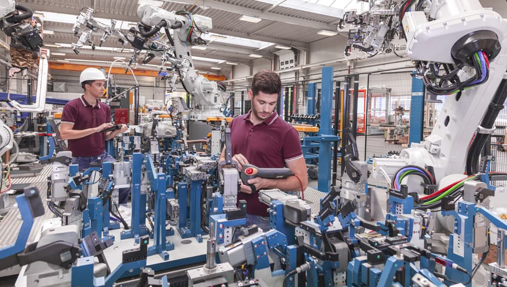 Zwei Mitarbeiter in einem Industrieunternehmen kontrollieren Geräte. | Motiv ©Herrndorff  - stock.adobe.com | © stock.adobe.com, Dezember 2019