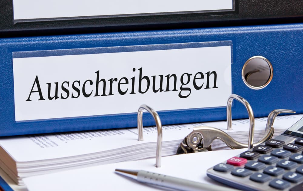 F Ausschreibung 1 neu (jpg) | Motiv © DOC RABE Media - Fotolia.com | © Fotolia.com, Mai 2014 Schreibtisch mit Papieren, Taschenrechner und blauem Ordner mit Aufschrift "Ausschreibungen" | Motiv © DOC RABE Media - Fotolia.com | © Fotolia.com, Mai 2014
